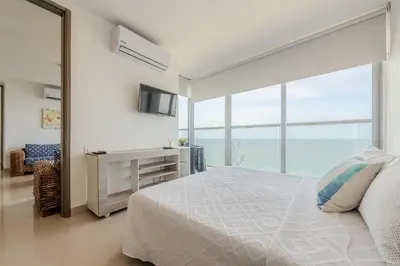 a bedroom with a bed and a large window at 2102 Morros City - Espectacular Vista al Mar in Cartagena de Indias