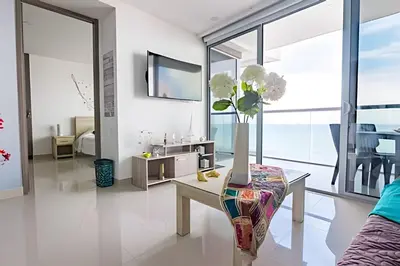 a living room with a table and a vase with flowers at Morros City-Espectacular Apto Vista al Mar Piso 8 in Cartagena de Indias
