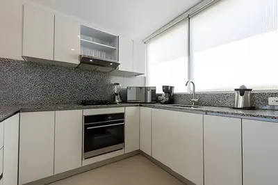 a white kitchen with white cabinets and appliances at Hermoso Apto Frente al Mar - Morros City 801 in Cartagena de Indias