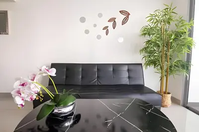 a living room with a black couch and a table at Lujoso Apto de 1 Hab en Piso 7 - Infinitum in Cartagena de Indias