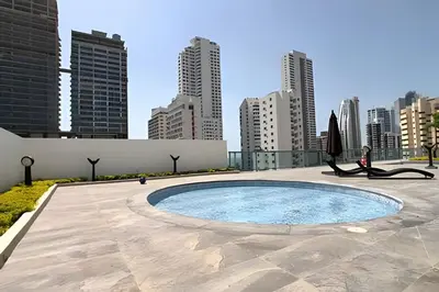 a woman sitting in a chair next to a pool in a city at Lujoso Apto de 1 Hab en Piso 7 - Infinitum in Cartagena de Indias