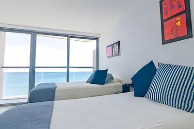 a bedroom with two beds and a large window at Espectacular Apto Piso 21 de 2 Hab - Morros City in Cartagena de Indias