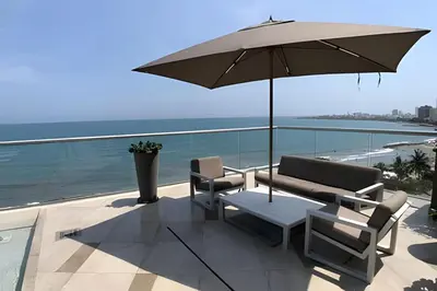 a patio with two chairs and an umbrella at Espectacular Apto Piso 21 de 2 Hab - Morros City in Cartagena de Indias