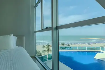a bedroom with a bed and a view of the ocean at Espectacular Vista Al Mar - Edificio Infinito 702 in Cartagena de Indias