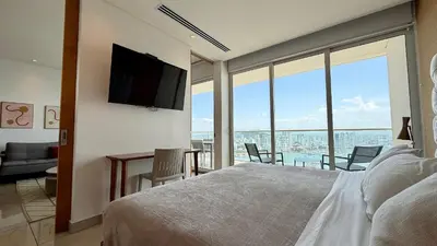 a bedroom with a bed and a view of the ocean at H2 Lujoso Apto 1 Hab Piso 23 Compl. Empleada in Cartagena de Indias