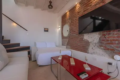 a living room with a white couch and a brick wall at El Mirador de la Catedral - Centro Histórico in Cartagena de Indias