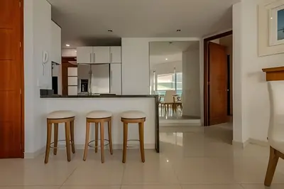 a kitchen with two bar stools and a counter at Espectacular Vista Al Mar - Ed. Infinito 2302 in Cartagena de Indias
