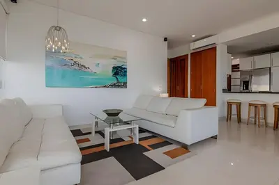 a living room with a white couch and a table at Espectacular Vista Al Mar - Ed. Infinito 2302 in Cartagena de Indias