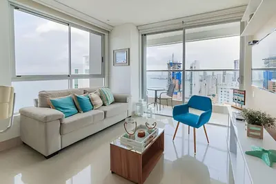 a living room with a couch and a blue chair at Lujoso Apto de 1 Habitación en Piso 24-Murano E in Cartagena de Indias