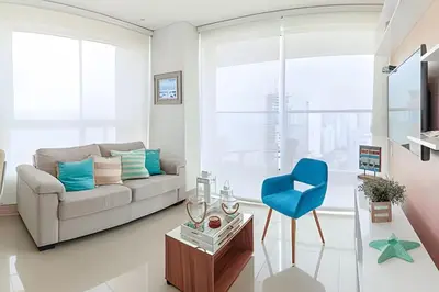 a living room with a couch and a blue chair at Lujoso Apto de 1 Habitación en Piso 24-Murano E in Cartagena de Indias