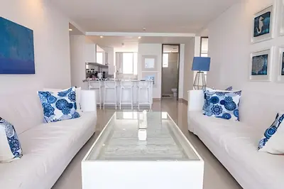 a living room with two white couches and a glass table at Espectacular Apto de 2 Hab Piso 24 - Morros City in Cartagena de Indias