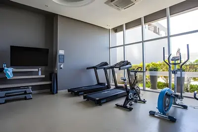 a gym with three tread machines and a flat screen tv at Espectacular Apto de 2 Hab Piso 24 - Morros City in Cartagena de Indias