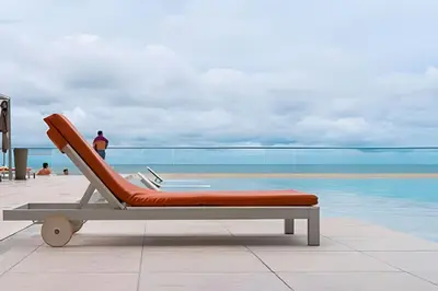 a lounge chair sitting next to a swimming pool at Espectacular Apto de 2 Hab Piso 24 - Morros City in Cartagena de Indias