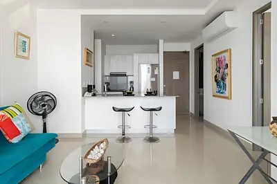 a living room with a blue couch and a kitchen at Lujoso Apto de 1 Habitación en Piso 40-Morros City in Cartagena de Indias