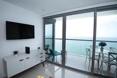 a living room with a television and a table with chairs at Espectacular Apto 1 Hab en Bocagrande - 2504 in Cartagena de Indias
