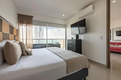 a bedroom with a large bed and a large window at Infinitum - Spectacular sea view 25th floor apt in Cartagena de Indias