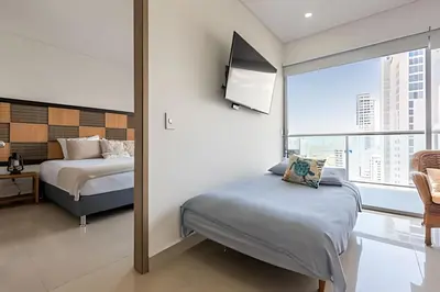a bedroom with two beds and a large window at Infinitum - Spectacular sea view 25th floor apt in Cartagena de Indias