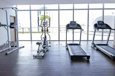 a gym with three tread machines in a room at Infinitum - Spectacular sea view 25th floor apt in Cartagena de Indias
