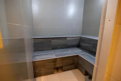 a small walk in shower with wooden cabinets in a room at ¡Espectacular Vista a la bahía! Piso 26 H2 Hyatt in Cartagena de Indias