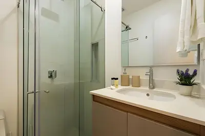 a bathroom with a sink and a glass shower at Apto con balcón en en Centro Historico - Zaher G in Cartagena de Indias