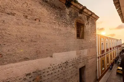 a large brick wall next to a building at Apto con balcón en en Centro Historico - Zaher G in Cartagena de Indias