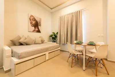 a bedroom with a bed and a table with chairs at Espectacular apto en Centro Histórico - Zaher F in Cartagena de Indias