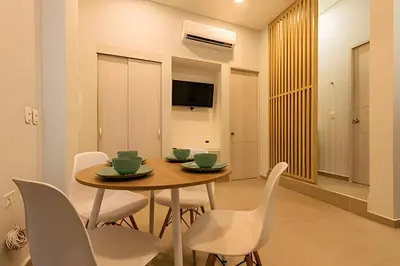 a dining room with a table and white chairs at Espectacular apto en Centro Histórico - Zaher F in Cartagena de Indias