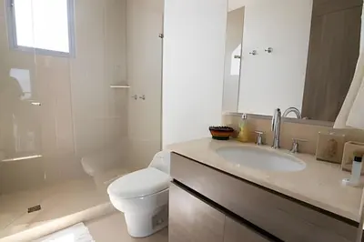 a white bathroom with a toilet and a sink at Lujoso Apto de 2 Hab en piso 26 - Morros City in Cartagena de Indias
