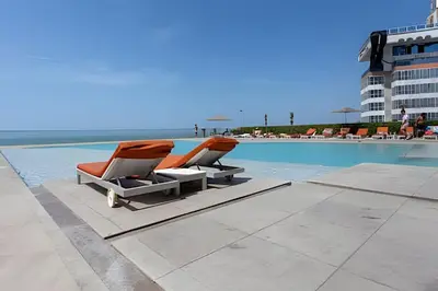 two lounge chairs sitting next to a swimming pool at Lujoso Apto de 2 Hab en piso 26 - Morros City in Cartagena de Indias