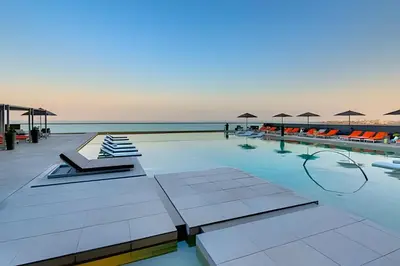 a swimming pool with chairs and umbrellas at Piso 27 - Espectacular apartamento en Bocagrande in Cartagena de Indias