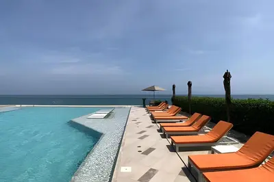 a row of lounge chairs next to a swimming pool at Piso 27 - Espectacular apartamento en Bocagrande in Cartagena de Indias