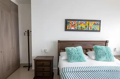 a bedroom with a bed with blue pillows at Espectacular Apto de 2 Hab en Piso 27-Morros City in Cartagena de Indias
