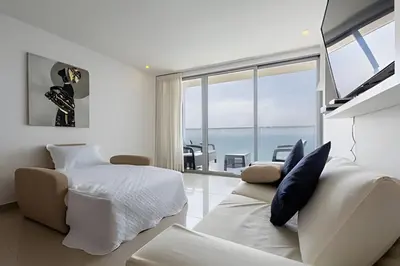 a bedroom with a bed and a couch and a window at 3605 Morros City - Paraiso en Cartagena in Cartagena de Indias