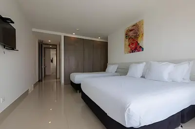 a hotel room with two beds and a flat screen tv at 3605 Morros City - Paraiso en Cartagena in Cartagena de Indias