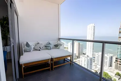 a bed on a balcony with a view of the city at Infinitum Espectacular apto piso 28 vista al mar in Cartagena de Indias