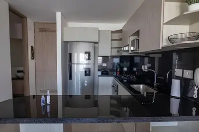 a kitchen with a black counter top with a refrigerator at Infinitum Espectacular apto piso 28 vista al mar in Cartagena de Indias