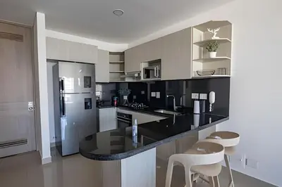 a kitchen with a black counter and a refrigerator at Infinitum Espectacular apto piso 28 vista al mar in Cartagena de Indias