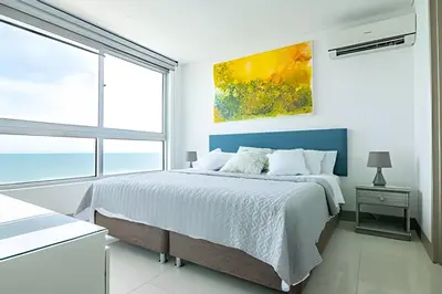 a bedroom with a bed and a large window at Lujoso Apto Vista al Mar Piso 34 - Palmetto Beach in Cartagena de Indias