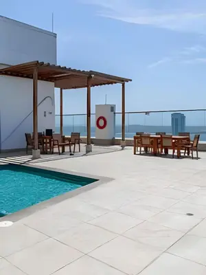 a patio with a table and chairs and a pool at Lujoso Apto Vista al Mar Piso 34 - Palmetto Beach in Cartagena de Indias