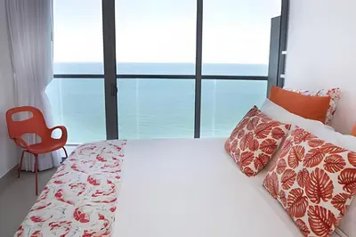 a bedroom with a bed and a large window at Morros City - Lujoso Apto con vista al mar Piso 28 in Cartagena de Indias