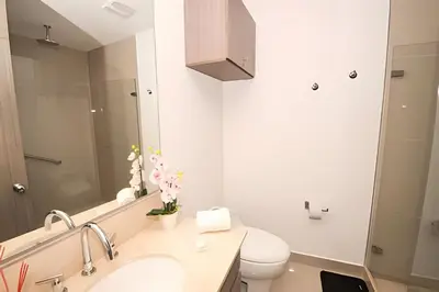a bathroom with a sink and a toilet and a mirror at Morros City - Lujoso Apto con vista al mar Piso 28 in Cartagena de Indias