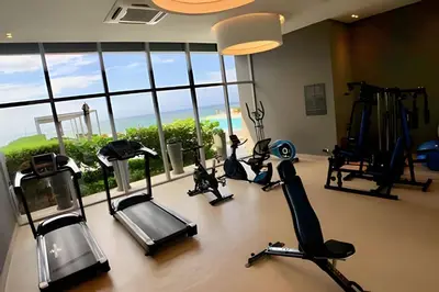 a gym with treadmills and exercise bikes in a room with windows at Morros City - Lujoso Apto con vista al mar Piso 28 in Cartagena de Indias