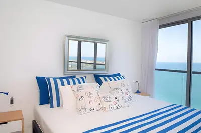 a bedroom with a bed with blue and white pillows at Morros City - Lujoso Apto con vista al mar Piso 28 in Cartagena de Indias