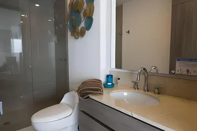 a bathroom with a sink and a toilet and a mirror at Lujoso Apto de 1 habitacion en piso 29-Morros City in Cartagena de Indias