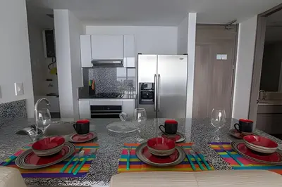 a kitchen with a table with plates and wine glasses at Lujoso Apto de 1 habitacion en piso 29-Morros City in Cartagena de Indias