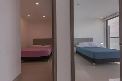 two beds in a room with a mirror at Lujoso Apto de 2 Habitaciones Piso 32- Morros City in Cartagena de Indias