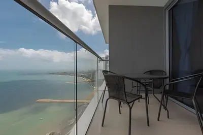 a balcony with a table and chairs looking out at the ocean at Lujoso Apto de 2 Habitaciones Piso 32- Morros City in Cartagena de Indias