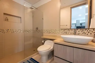 a bathroom with a sink and a toilet and a mirror at Palmetto Sunset piso 33 - Vista espectacular in Cartagena de Indias