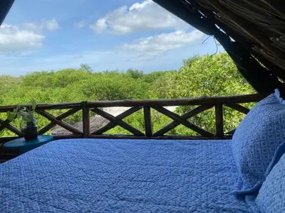 a bed in a tent with a wooden fence at Pirita Beach House in Santa Ana