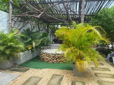 a garden with palm trees and a pergola at Pirita Beach House in Santa Ana